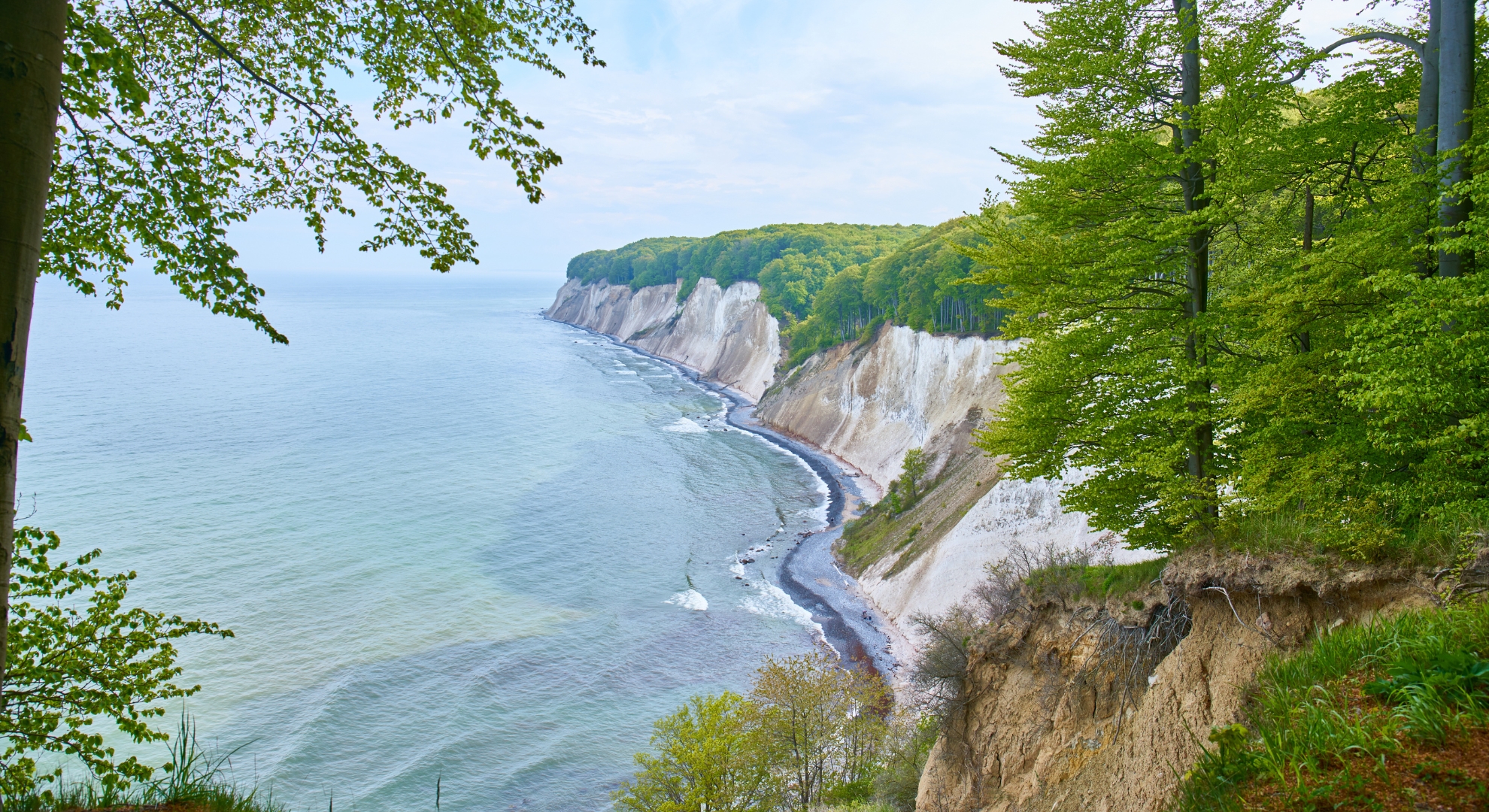 A scenic view of the Balatic Sea from a cliff, showcasing the coastline and blue waters below.