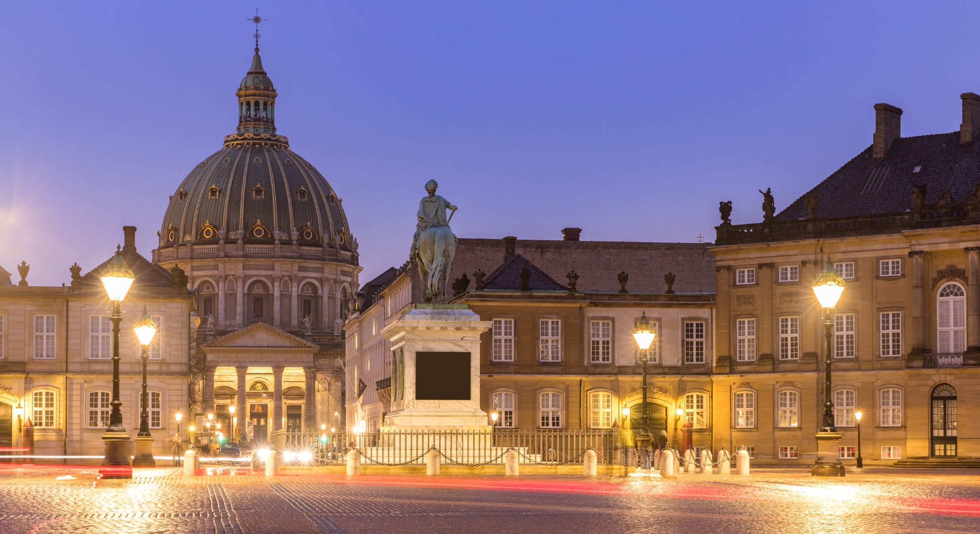 A historic building with a clock tower and a statue in front, symbolizing Denmark's cultural heritage.