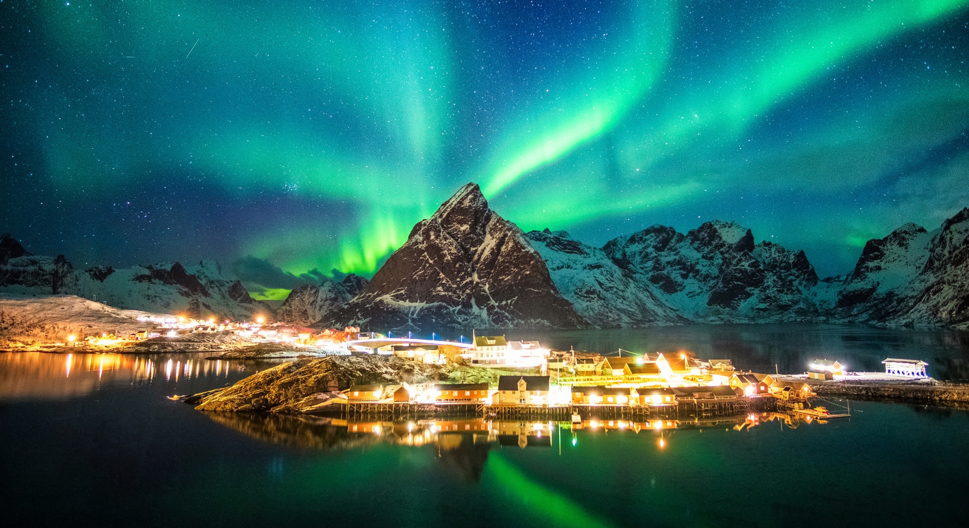 A stunning display of the aurora borealis lights the sky over a mountain range in Northern Europe, creating a magical scene.