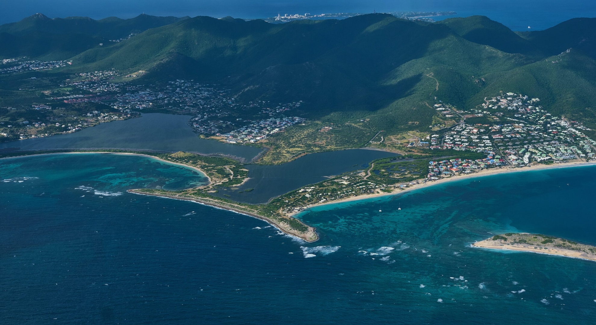 Aerial view of St. Martin, showcasing the island surrounded by vibrant blue ocean waters.
