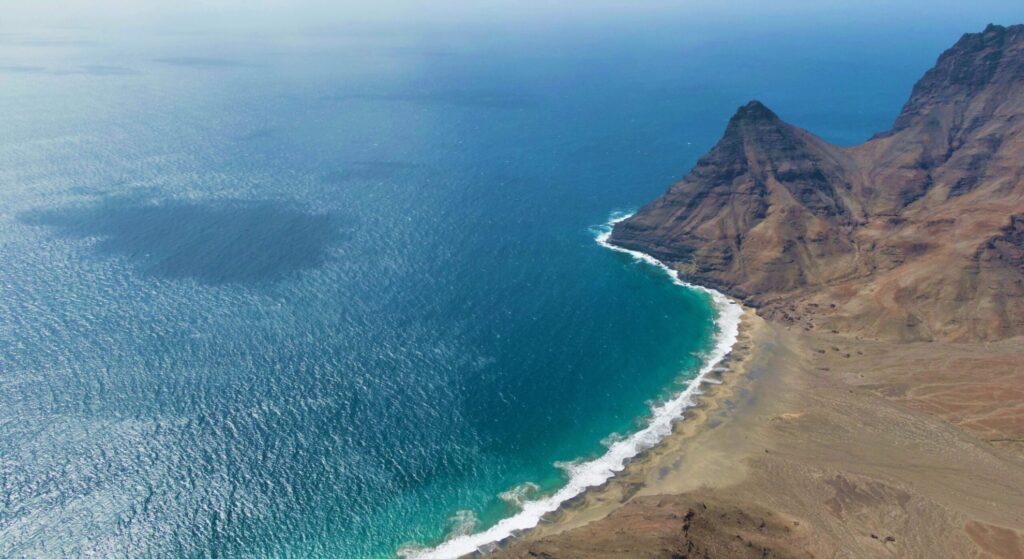 Overhead image of Cape Verde's ocean and cliffs, highlighting the dramatic coastline and rich blue sea.