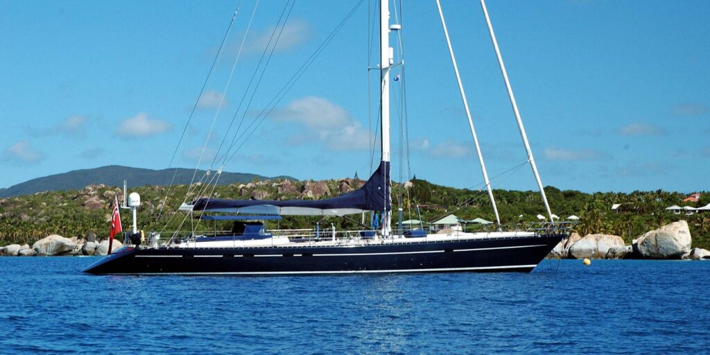 The DARK STAR OF LONDON yacht sails gracefully across the open ocean under a clear blue sky.