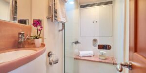 A bathroom on the DARK STAR OF LONDON yacht featuring a sink, toilet, and shower in a modern design.